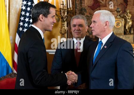 U.S Vice Presidente Mike Pence, destra saluta Juan Guaido, l'auto-proclamato presidente ad interim del Venezuela, sinistra, come il Presidente colombiano Ivan Duque si affaccia sulla prima di una riunione del Gruppo Lima Febbraio 25, 2019 a Bogotà, in Colombia. Gli Stati Uniti è un sostegno Guaido in un tentativo di porre fine alla crisi umanitaria in Venezuela. Foto Stock