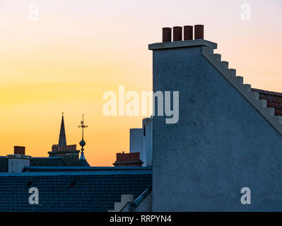 Leith, Edimburgo, Scozia, Regno Unito, 26 febbraio 2019. Regno Unito Meteo: un bagliore arancione nel cielo visto al tramonto su vecchi tetti di Leith su un record giornata invernale con i più caldi in inverno la temperatura registrata Foto Stock