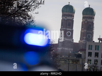 26 febbraio 2019, il Land della Baviera, München: una luce blu di una pattuglia di polizia può essere visto nella parte anteriore delle torri della Frauenkirche. Foto: Lino Mirgeler/dpa Foto Stock