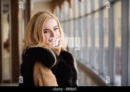 Bella ragazza guarda attraverso la finestra del centro business Foto Stock