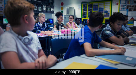 Studenti di scuola materna a scrivanie in aula Foto Stock