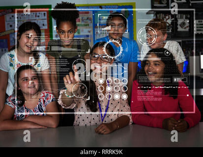 Insegnanti e studenti di scuola materna utilizzando avveniristico touch screen in aula Foto Stock