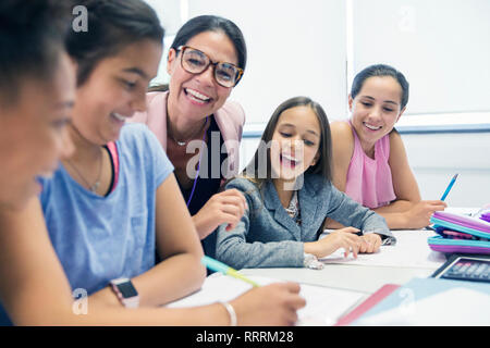 Entusiasta insegnante femminile e junior high school girl gli studenti in aula Foto Stock