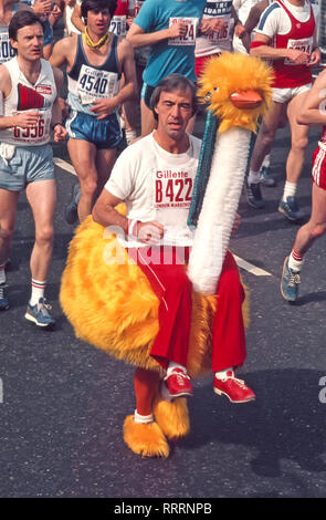 Archivio storico anni '80 visione guardando verso il basso il comico britannico e intrattenitore Bernie Clifton correndo sul suo costume da burattini di struzzo arancione Oswald l'Ostrich nella seconda gara della Maratona di Londra sponsorizzata da Gillette nel 1982 un'immagine archivistica anni '80 all'inizio su Blackheath Common London England UK Foto Stock