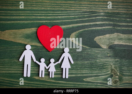 Family Health, assicurazione vita concetto. Catena di legno in forma di famiglia con cuore rosso. Vista superiore, laici piatta Foto Stock