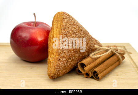 In casa di pasta sfoglia fatturati Apple, Apple e bastoncini di cannella su un tagliere di legno isolato su sfondo bianco Foto Stock