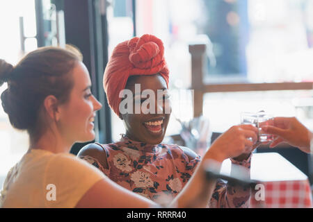 Felice di donne giovani amici assunzione di alcool shot in bar Foto Stock