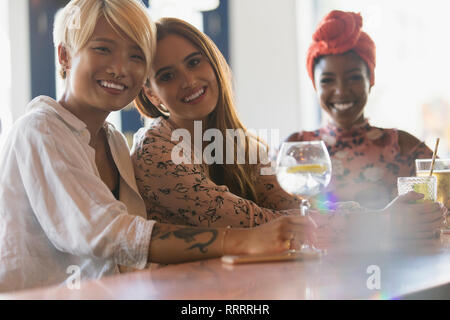 Ritratto sorridente di donne giovani amici bevendo un cocktail nel bar Foto Stock