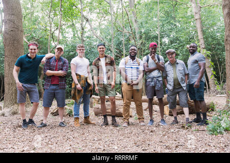 Ritratto fiducioso mens gruppo escursionisti in piedi in una fila di boschi Foto Stock