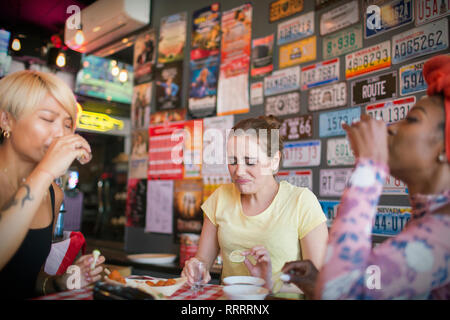 Giovani donne amici prendendo tequila scatti in bar Foto Stock