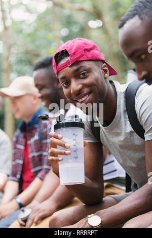 Ritratto uomo sorridente acqua potabile, preparazione per escursione Foto Stock