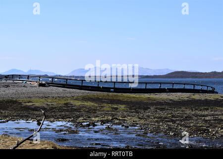 Flottante gabbia di pesce delle tubature HDPE per l'allevamento del salmone, in costruzione sulle rive di Loch Creran, Argyll. Magnifico cielo blu e lontane colline. Foto Stock