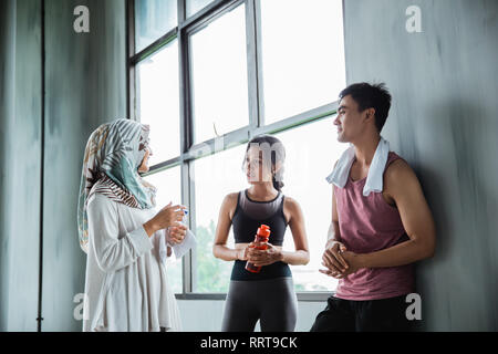 Amici in chat con la palestra dopo esercizio insieme Foto Stock