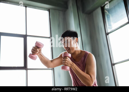Uomo che utilizza il manubrio facendo qualche esercizio di inscatolamento Foto Stock