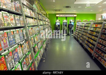 Le persone che giocano in-store console per giochi per computer Foto Stock