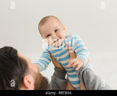 Papà azienda happy baby figlio fino in aria Foto Stock