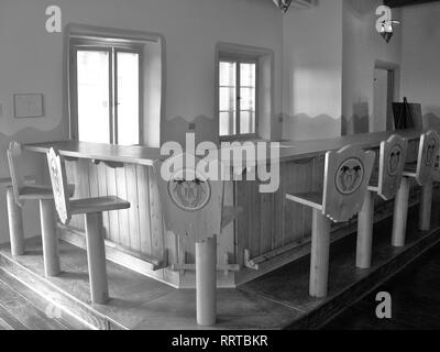 Interno della ex fermata sul ciglio della strada nel deserto dipinto a est di Flagstaff, in Arizona lungo la vecchia US Route 66. Le immagini in bianco e nero mostra 6 sedie . Foto Stock