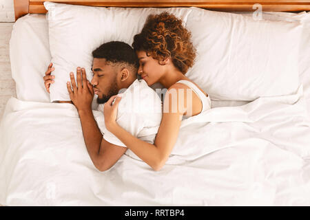 Amare giovane dormire nel letto e abbracciando Foto Stock