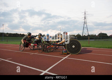 Gli atleti paraplegici huddling sulla via dello sport, corsi di formazione per la gara di sedia a rotelle Foto Stock