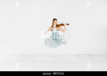 Ragazza flottante in vestito blu suona il violino su sfondo bianco Foto Stock