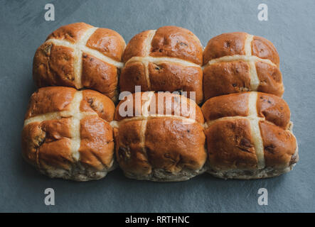 Sei Hot Cross i panini su una scheda di ardesia Foto Stock