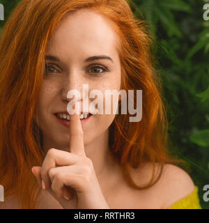 Giovane ragazza redhead che chiedono di mantenere il silenzio Foto Stock