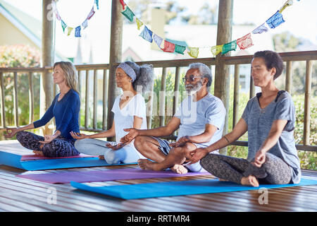 La gente serena meditazione nella capanna durante il ritiro di yoga Foto Stock