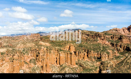 Vista aerea di Danxia Binggou Canyon rilievi in Zhangye, Sunan Regione, Provincia di Gansu, Cina. Pietra arenaria rossa rocce del Geoparco. Nuvole basse e blu Foto Stock