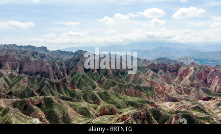 Vista aerea di Danxia Binggou Canyon rilievi in Zhangye, Sunan Regione, Provincia di Gansu, Cina. Sharp picchi appuntiti nel Geoparco. Nuvole basse e blu Foto Stock