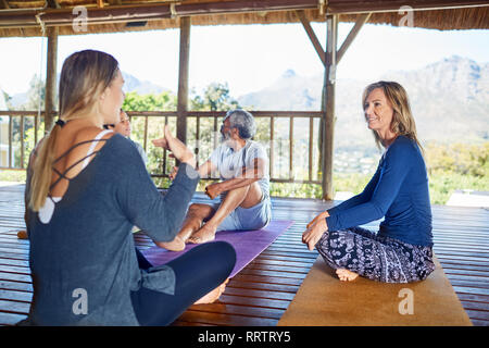 Le donne parlano in rifugio durante il ritiro di yoga Foto Stock