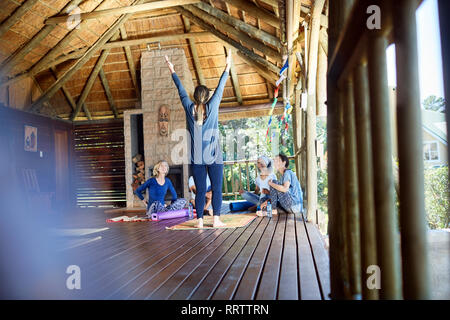 La donna conduce ritiro di yoga in baita Foto Stock