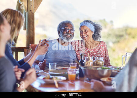 Felice coppia senior godendo di pasto sano nella capanna durante il ritiro di yoga Foto Stock