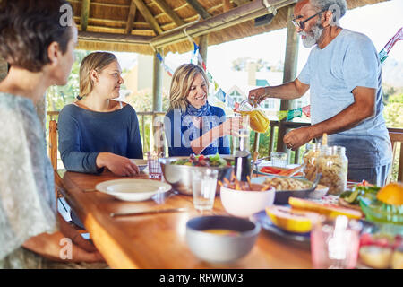 Gli amici sorseggiando una sana prima colazione nella capanna durante il ritiro di yoga Foto Stock