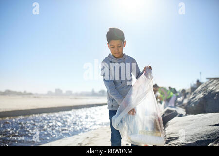 Ragazzo volontario pulizia lettiera di sunny beach Foto Stock