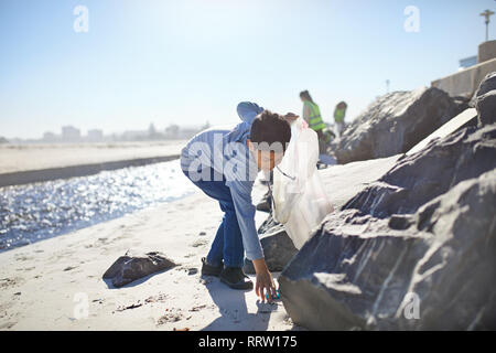 Ragazzo volontario il prelievo di lettiera di sunny beach Foto Stock