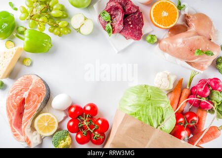 Cibo sano concetto di shopping ed equilibrata dieta ingredienti - carne, pesce, frutta e verdura. Alimenti freschi con carta shopping bag, vista dall'alto sul backgr bianco Foto Stock