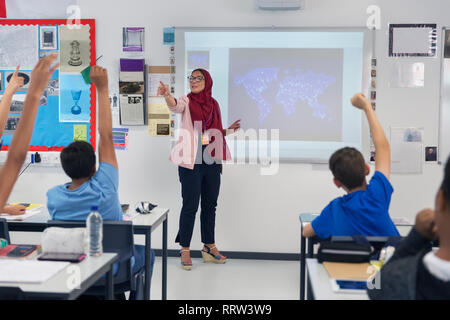 Insegnante femminile in hijab lezione leader, invitando gli studenti in aula Foto Stock