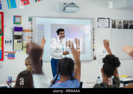 Sorridente insegnante maschio che conduce la lezione in aula Foto Stock