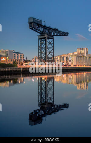 Glasgow/SCOZIA - 20 Settembre 2016: Il Finnieston gru contro un cielo blu, con uno specchio di riflessione di immagine nel fiume Clyde Foto Stock