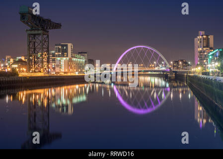 Glasgow/SCOZIA - 20 Settembre 2016: il Clyde Arc e degli edifici circostanti si riflette nel fiume Clyde di notte Foto Stock