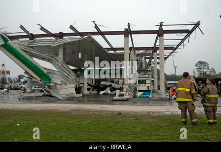 Vigili del fuoco volontari a stare di fronte ad un distrutto BP stazione di gas a seguito di un EF-2 tornado in Theodore, Alabama, 9 marzo 2011. Foto Stock