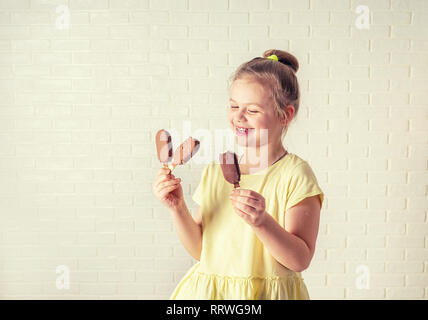 Felice bambina mangiare ghiaccioli al tempo estivo, spazio di copia Foto Stock