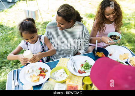 Famiglia godendo il pranzo al campeggio Foto Stock