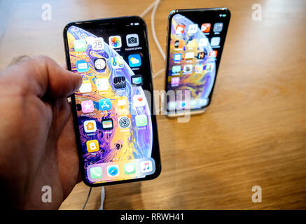 Parigi, Francia - Oct 25, 2018: il cliente all'interno di Computer Apple Store tenendo iphone più recente smartphone XS telefono in oro di colore nero - guardando la schermata Home con app - POV Foto Stock