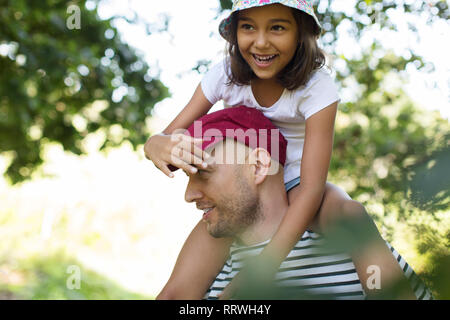 Padre che porta felice figlia sulle spalle Foto Stock