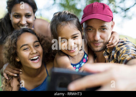 La famiglia felice tenendo selfie con la fotocamera del telefono Foto Stock