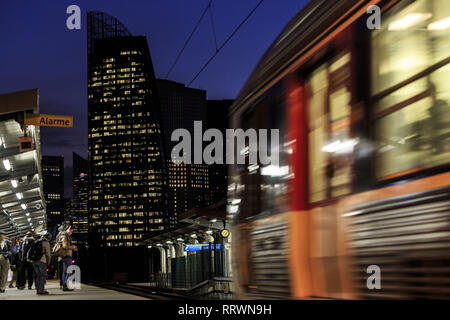 Pendolari attendere sulla piattaforma per l'arrivo dei loro treni pendolari, Courbevoie, Francia Foto Stock