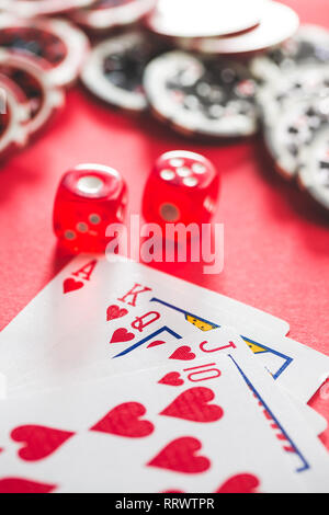 Carte da poker e dadi sulla tabella rossa. Foto Stock