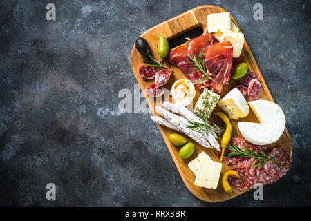 Scheda di antipasti con affettati, prosciutto, salame, formaggio, olive e vino rosso. Foto Stock