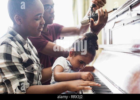 Fratelli e sorelle suonando piano Foto Stock